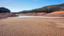 Landscape Of Low Water And Dry Land In Advance, Severe Drought In The Reservoir Of Portugal. Ecological Disaster, Soil Dehydration. Desert, Drought,