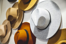 Closeup Shot Of Cool Hats In Various Colors Hung On The White Wall