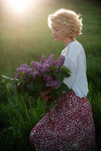 Woman Blonde In White Blouse On Sunset With Flowers