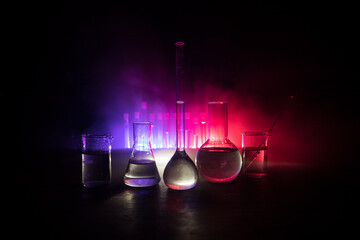 Test glass flask with solution in research laboratory. Science and medical background. Laboratory test tubes on dark toned background , science research equipment concept