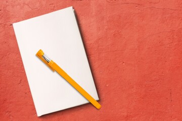 Poster - Notepad for writing text with pen on a red background.