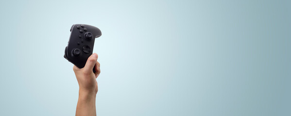 Fototapete - hand holding a video game controller - concept winning in a game