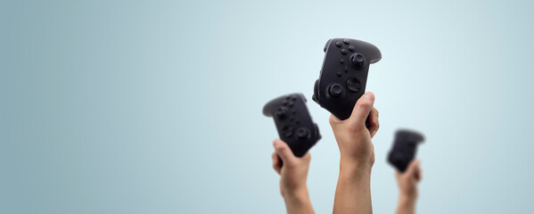 Fototapete - hand holding a video game controller - concept winning in a game