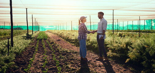 im leaving the farm in your capable hands. full length shot of two young farmers shaking hands while