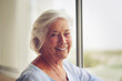 My age does not define my happiness. Portrait of a happy and relaxed senior woman standing next to a window indoors.