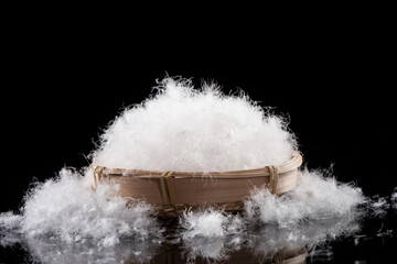 soft fluffy white down feather on black background.