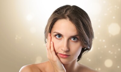 Poster - Beautiful young woman with clean fresh skin on blur bokeh background, Face care, Facial treatment, Cosmetology, beauty and spa concept