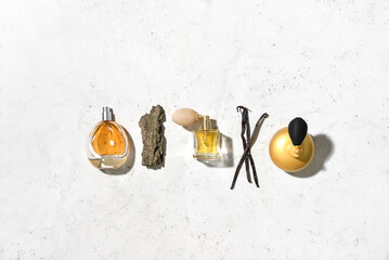 Bottles of different perfumes on light background, top view