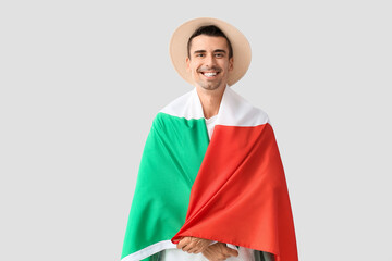 Wall Mural - Young man with Italian flag on light background