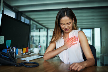 Poster - What was that sharp pain. Shot of a young businesswoman suffering with chest pain while working in an office.