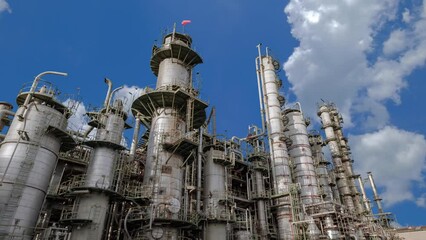 Wall Mural - Time lapse of industrial plant with heavy equipment of oil refinery on blue sky