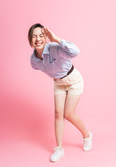 Portrait of young Asian girl posing on pink background