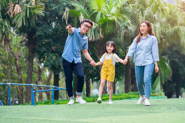 Wall Mural - Image of young Asian family playing together at park