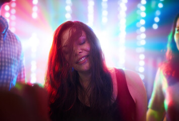 Poster - Feeling free on the dance floor. Shot of a young woman dancing in a nightclub.