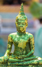Buddha Statue With Gold Leaf Flaking At The Grand Palace Bangkok.