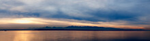 Wide Angle View Of Puget Sound With Olympic Mountain Range Beyond And Cloudy Sky.