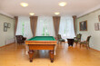 © Mint Images - Pool table and furniture in a games room, hotel.