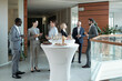 © pressmaster - Large group of intercultural people in formalwear communicating at buffet while standing by tables served with snacks and champagne