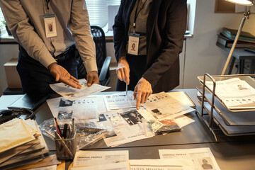 Aufkleber - Hands of intercultural agents of FBI discussing criminal profiles by workplace while one of them pointing at photo of suspect