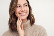 Portrait of a happy brunette caucasian woman smiling and looking beautiful standing isolated on white background in a sweater. Young female girl with a perfect smile.