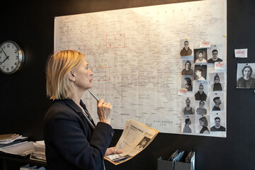 Aufkleber - Mature female agent of FBI with documents matching facts of crime series while standing in front of board and looking at map
