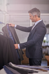 Poster - Youve got to dress for success. Shot of a mature businessman looking at a suit in a clothing store.