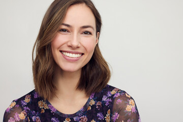 Portrait of a happy brunette caucasian and beautiful woman smiling and standing isolated on grey concrete background. Young female girl.