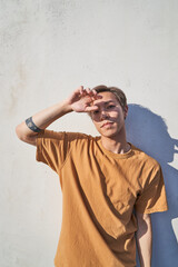 Man in front of wall with hand in front of face