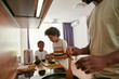 © Svitlana - Boy making sandwich near father frying on pan