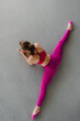© Denys Kurbatov - Beautiful flexible girl doing split exercise in gym, top view photo