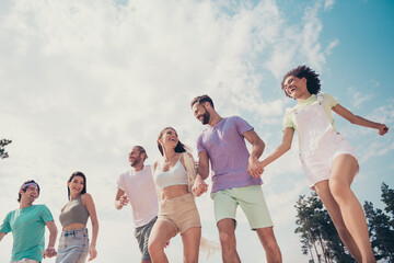 Poster - Photo of energetic carefree dreamy friends hold hands walk wear casual outfit nature summer seaside beach