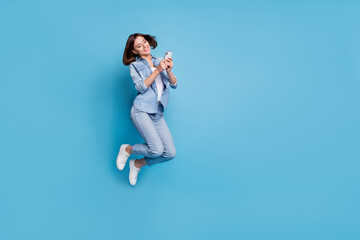Wall Mural - photo of pretty sweet lady dressed denim shirt jumping typing gadget empty space isolated blue color