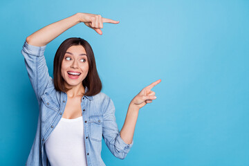 Wall Mural - portrait of positive person look direct two fingers empty space offer novelty isolated on blue color