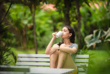 young beautiful woman person are happy and enjoy with coffee drink in the morning at home, relax lifestyle by holding coffee or tea cup at nature outdoor park, smile pretty girl with freedom time