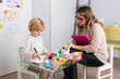 © ADDICTIVE STOCK - Psychologist sitting near boy drawing on paper