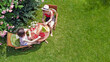 © Iuliia Sokolovska - Women friends eating together outdoors in summer garden, girls have picnic and relaxing in park, aerial view of table with food and drinks from above