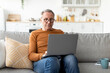 © Prostock-studio - Confident casual mature male using laptop at home