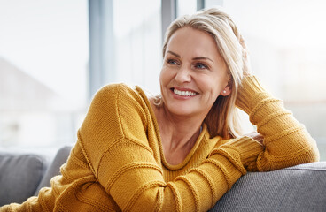 Poster - Relaxing really lifts the spirits. Shot of an attractive mature woman relaxing on the sofa at home.