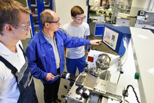 Young Apprentices In Technical Vocational Training Are Taught By Older Trainers On A Cnc Lathes Machine