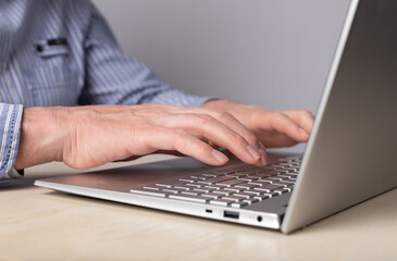 Poster - Man hands closeup typing on laptop keyboard. Using computer for distant work, online education, social communication. High quality photo