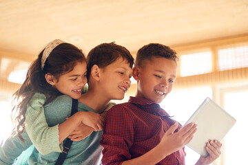 Wall Mural - Todays kids are more tech savvy. Shot of young children using a digital tablet together at home.