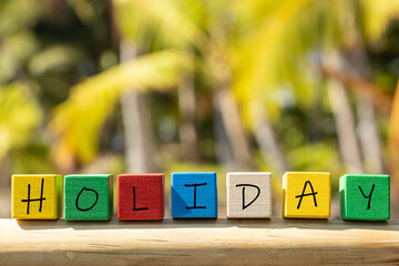 Fototapete - colored blocks with the word Holiday on a background of tropical palm trees, tourist concept, Vacation and rest in warm and friendly countries