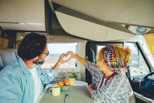 Happy Mature Couple Doing Heart Gesture Sign With Hands Together Inside Modern Camper Van Vehicle. Concept Of Traveler And Road Trip Holiday Vacation Lifestyle. Man And Woman