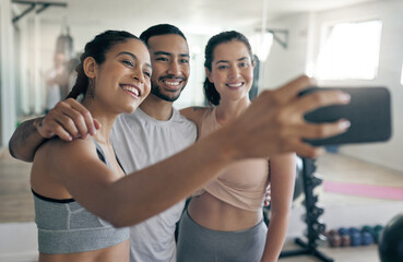 Sticker - Online to spread some fitness inspiration. Shot of three young athletes taking a selfie while standing together in the gym.