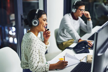 Leinwandbilder - Taking care of their customers. Shot of young call centre agents working late in an office.