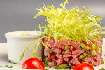 Wall Mural - Beef tartare with frieze salad and tomatoes is on a plate