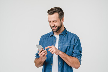 happy caucasian young man using smart phone cellphone for calls, social media, mobile application on