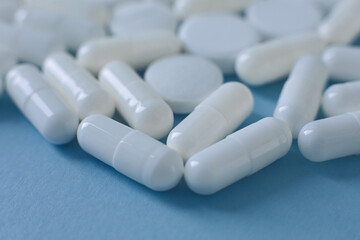 Wall Mural - Close up white pills on blue background