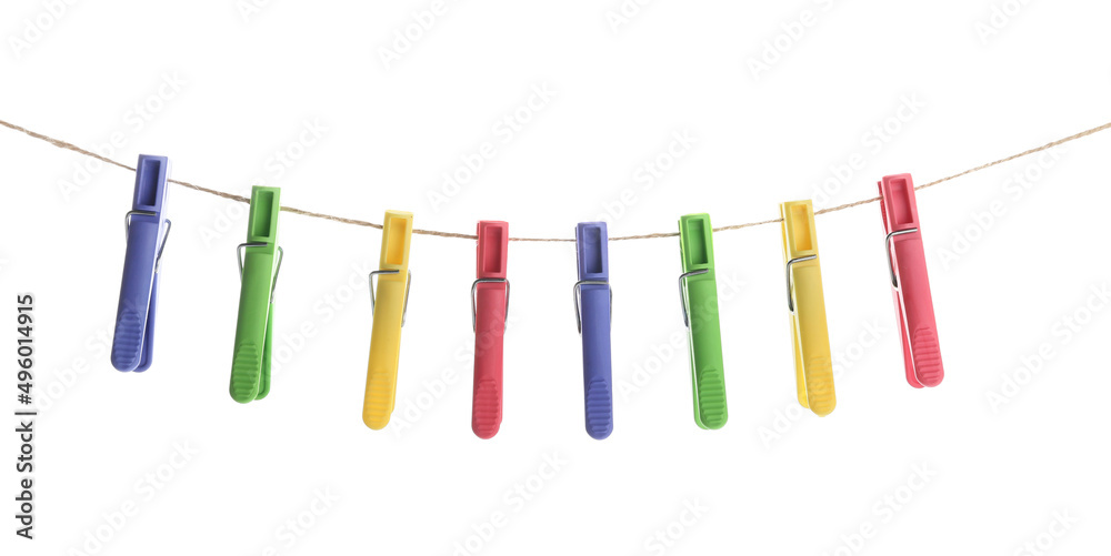 Plastic clothes pins hanging on rope against white background