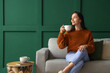 © Pixel-Shot - Beautiful young woman with cup of tea resting on couch at home